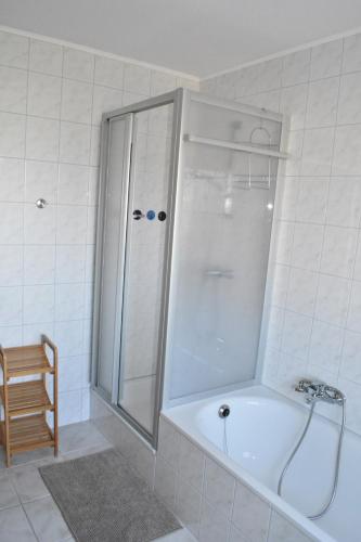 a bathroom with a shower and a bath tub at Wohnung "Strandturm" in Wremen am Deich in Wremen