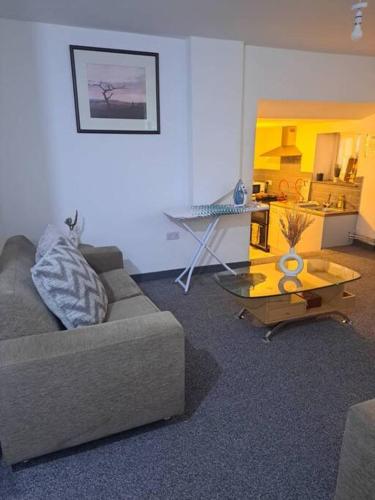 a living room with a couch and a table at 1 Bedroom Flat Available in Oldham