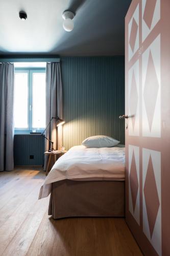 a bedroom with a bed and a window and a door at Hotel De Londres in Brig