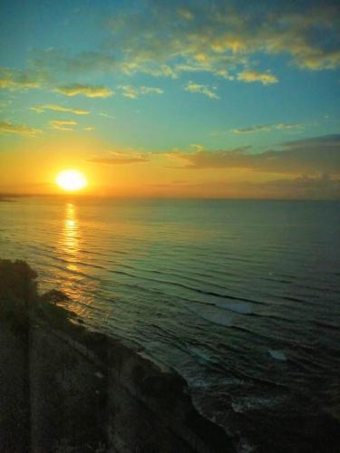 a sunset over the ocean with the sun setting at Bello amanecer in Santo Domingo