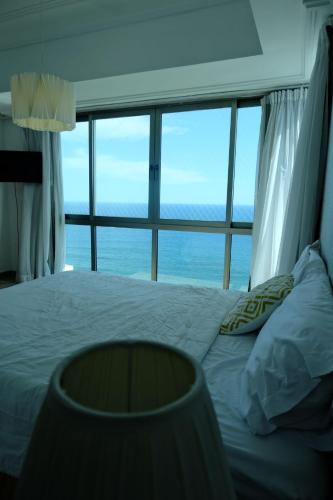 a bedroom with a bed with a view of the ocean at Bello amanecer in Santo Domingo