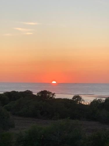 a sunset over the ocean with the sun in the horizon at Appartements Armonía Sea View in Briech