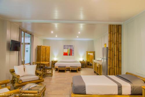 a hotel room with two beds and a living room at Hotel Plaza Yara in Manuel Antonio