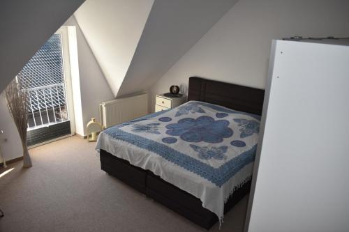 a bedroom with a bed with a blue and white comforter at Wohnung "Strandturm" in Wremen am Deich in Wremen
