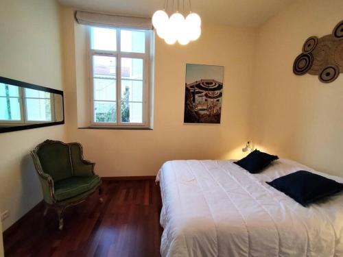 1 dormitorio con 1 cama, 1 silla y 1 ventana en 2 Bebrooms Duplex en Cannes