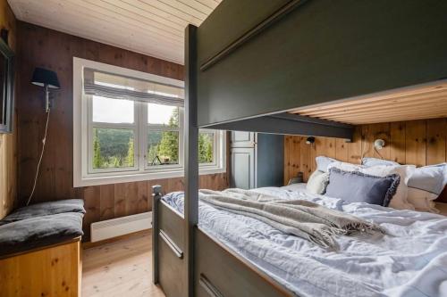 a bedroom with a large bed and a window at Your Ideal Getaway Awaits in This Charming Cabin Retreat in Nord Torpa