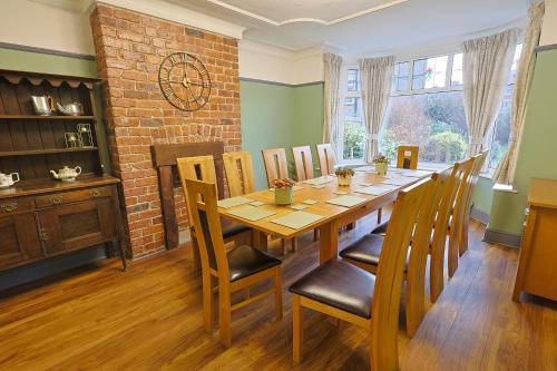 a dining room with a wooden table and chairs at Waves of Memories Rhos on Sea in Llandrillo-yn-Rhôs