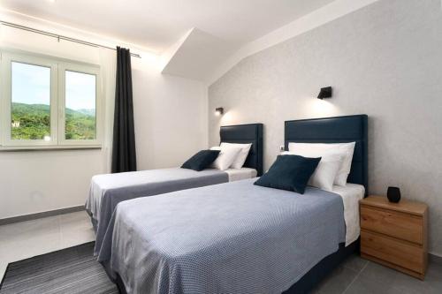 a hotel room with two beds and a window at Villa HillSea in Mošćenice