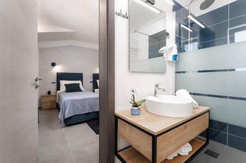 a bathroom with a sink and a bed in a room at Villa HillSea in Mošćenice