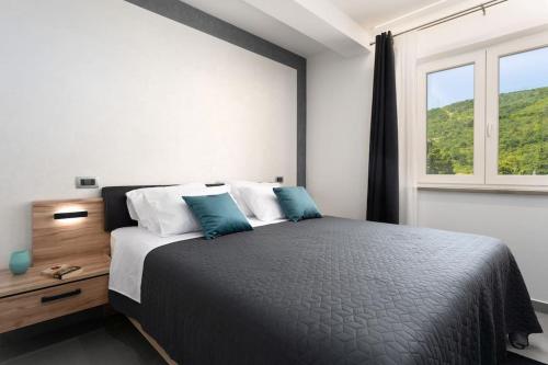 a bedroom with a large bed and a window at Villa HillSea in Mošćenice
