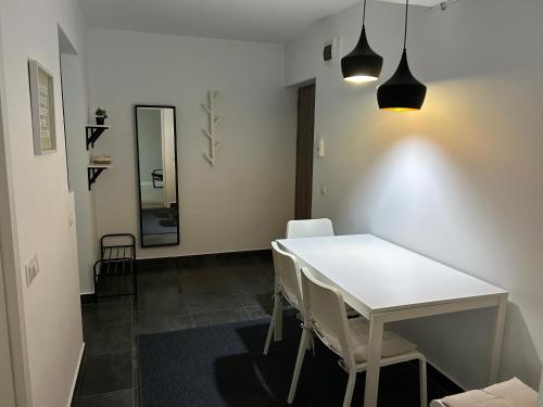 a dining room with a white table and chairs at Marc Apartament in Turda