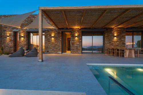 an outdoor patio with a swimming pool and a building at Villa Mirabilis in Ios Chora