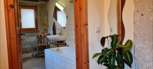 a bathroom with a tub and a sink at Ferienwohnung am Bächelweg in Bad Schandau