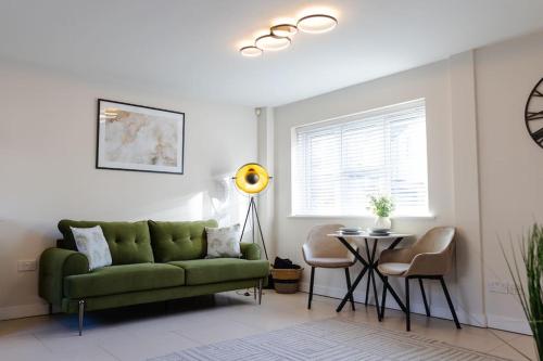 uma sala de estar com um sofá verde e uma mesa em Stylish 1 bed apartment with free parking em Cardiff