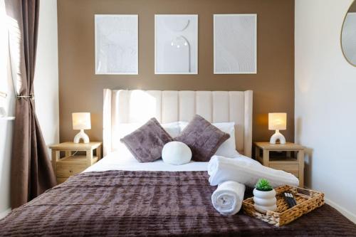 een slaapkamer met een bed met kussens en handdoeken erop bij Stylish 1 bed apartment with free parking in Cardiff