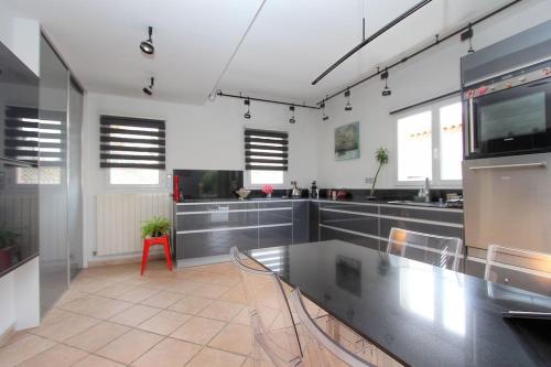une grande cuisine avec un comptoir en acier inoxydable dans l'établissement Villa avec piscine. Plage à 300m, à La Grande Motte