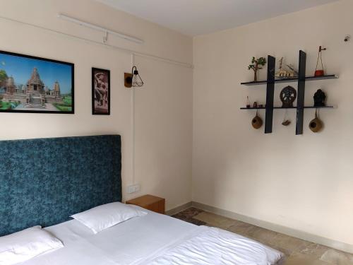 sypialnia z białym łóżkiem z niebieskim zagłówkiem w obiekcie Nest Tales Backpacker Hostel w mieście Khajuraho