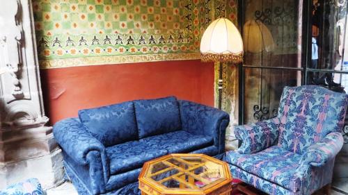 a living room with a blue couch and a chair at La Casa de la Marquesa in Querétaro