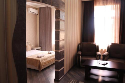 a bedroom with a bed and a room with a window at Olympic Hotel in Gyumri