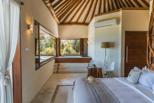 a bedroom with a bed and a large window at Hotel Casa Punta Coco & Beach Club - Adults Only in Holbox Island