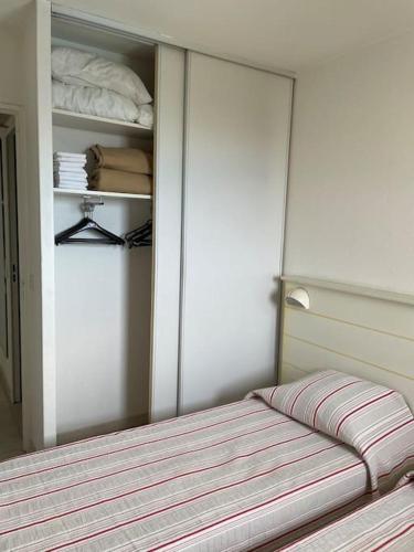 - une chambre avec un lit et un placard avec un couvre-lit dans l'établissement Appartement vue mer/piscine-Les pins bleus, à Juan-les-Pins