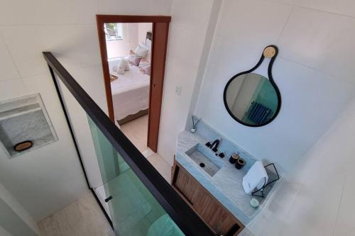 uma casa de banho com um lavatório e um espelho em Recanto na Olegário Maciel com garagem no Rio de Janeiro