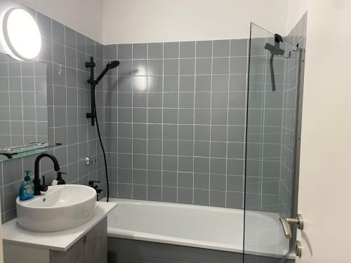 ein Bad mit einer Badewanne, einem Waschbecken und einer Dusche in der Unterkunft Deluxe dream home in Linz