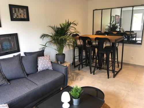 un salon avec un canapé, une table et des chaises dans l'établissement Appartement 3chambres/parking proche MONTPELLIER, à Castelnau-le-Lez