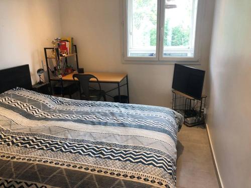 une chambre avec un lit, un bureau et une fenêtre dans l'établissement Appartement 3chambres/parking proche MONTPELLIER, à Castelnau-le-Lez