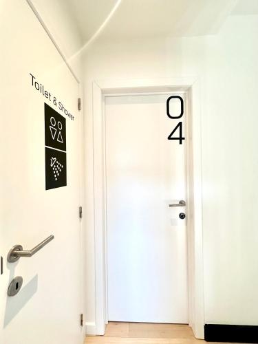 a white door in a hallway with a sign on the wall at My Haus European Commision in Brussels