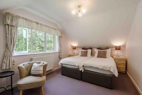 a bedroom with a bed and a chair and a window at Mireystock Indoor Pool, Games Bar, Spa Steam Cabin in Lydbrook