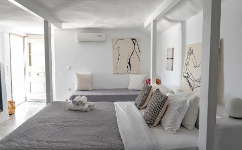 Habitación blanca con cama y sofá en Anemoi Resort en Náousa