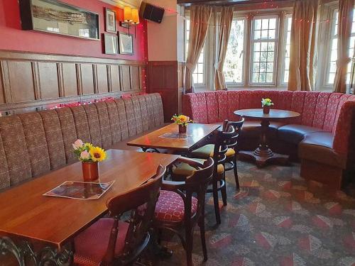 a restaurant with tables and chairs and a couch at The Airman in Feltham