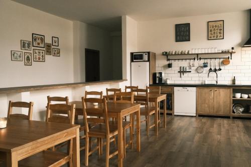 a restaurant with wooden tables and chairs and a kitchen at Horalka Apartments in Jáchymov
