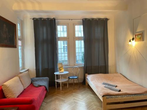a living room with a red couch and a window at Apartamenty i pokoje przy sopockim molo in Sopot