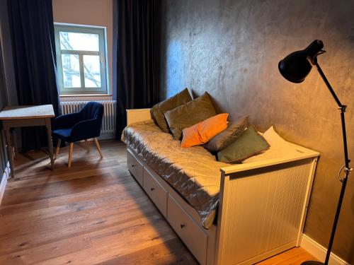 a bedroom with a couch with pillows on it at MARKT LIFE HOME APPARTMENTS in Lutherstadt Wittenberg