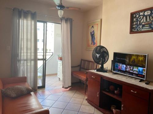 Il comprend un salon doté d'un canapé et d'une télévision à écran plat. dans l'établissement Apartamento centro de BC, à Balneário Camboriú