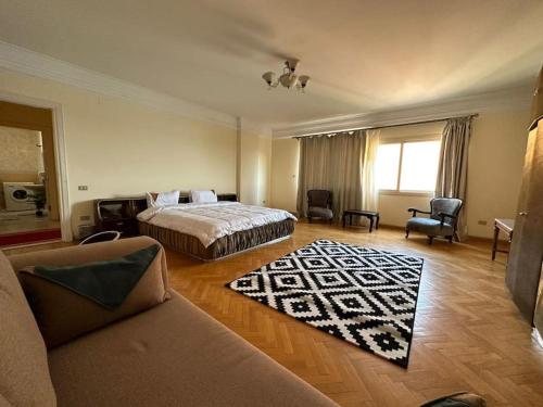 een hotelkamer met een bed en een bank bij Luxurious apartment for rent with Nile view for families only in Caïro