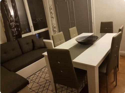 - un salon avec une table et un canapé dans l'établissement Chambre#1privée en colocation Vue sur Paris Tour Eiffel, à Cachan