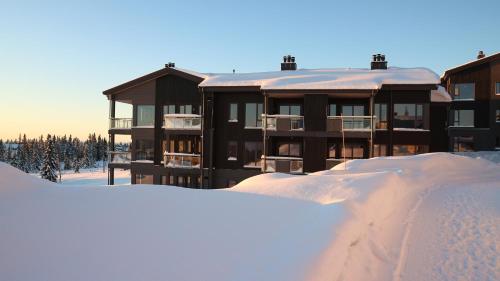 Ringsaker的住宿－Beautiful penthouse with panoramic view at Sjusjøen，积雪中积雪的建筑物
