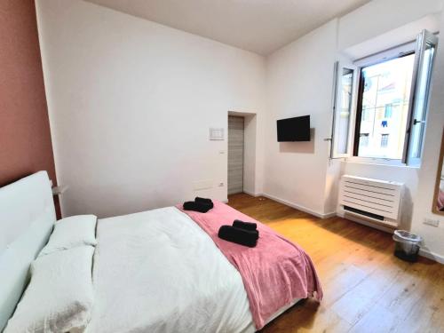 a bedroom with a bed with two black shoes on it at Morfeo B&B in Sassari