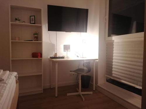 a bedroom with a desk and a chair next to a window at Apartamenty Jaskółcza in Bydgoszcz