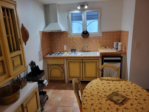 a kitchen with a table and a sink and a kitchen with a tableablish at La Chouette de Camargue in Aigues-Mortes