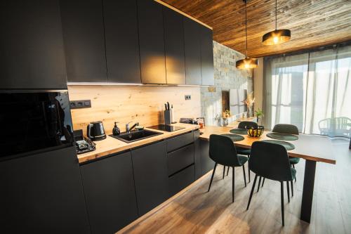 eine Küche mit einem Tisch, Stühlen und einem Waschbecken in der Unterkunft Apartmán C1 - Slovenský Raj in Hrabušice