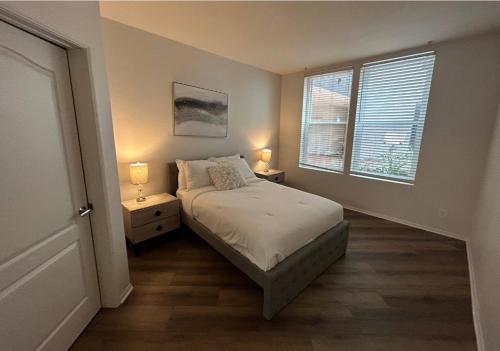 a bedroom with a bed and two lamps and a window at Westerly 2 bedroom apartment Marina Del Rey near Venice beach! in Los Angeles