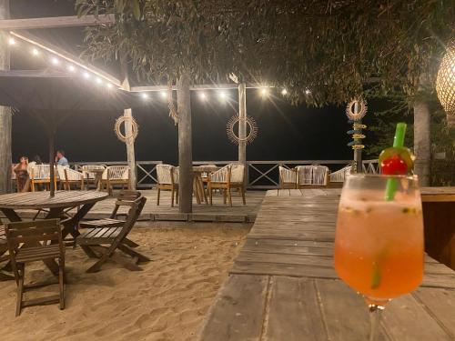 una bebida sentada en una mesa de madera frente a un restaurante en Mar Azul - Playa y Turismo en Camarones