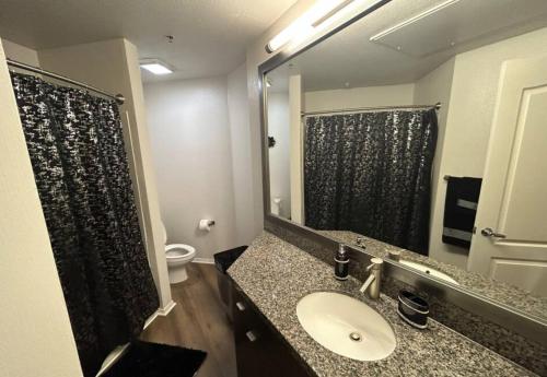 La salle de bains est pourvue d'un lavabo et d'un grand miroir. dans l'établissement Westerly 2 bedroom apartment Marina Del Rey near Venice beach!, à Los Angeles