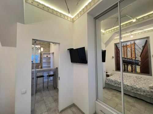 a room with a view of a bed and a kitchen at Center Apartment in Chişinău