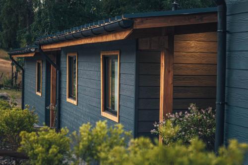 a blue cabin with a wooden roof and windows at Wincarayen Lodge & Cabañas in Panguipulli