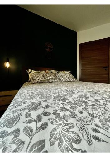 um quarto com uma cama com uma parede preta em Airport Accommodation Bedroom with Bathroom Self Check In and Self Check Out Air-condition Included em Mqabba